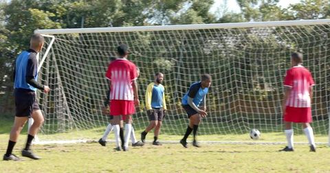 Men forming defensive wall during soccer match