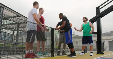 Diverse Male Basketball Players Talking on Outdoor Court