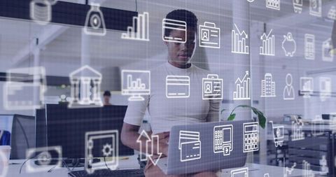 Female professional holding laptop in open office with data and finance icons overlay