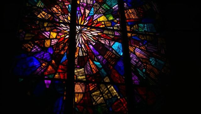 Vibrant radial stained glass art in church sanctuary