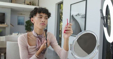 Elegant man perfecting makeup in contemporary home environment