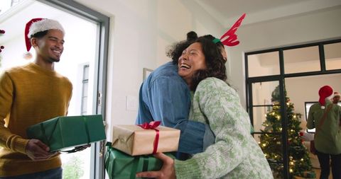 Diverse Friends Welcoming into Holiday Celebration with Warm Hugs and Gifts