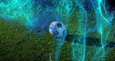 Soccer ball bouncing and rolling over grass with neon teal particle ribbons