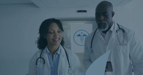 Healthcare Professionals Reviewing Patient Records in Hospital Corridor