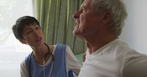 Doctor Helping Senior Man with Back Pain at Retirement Home