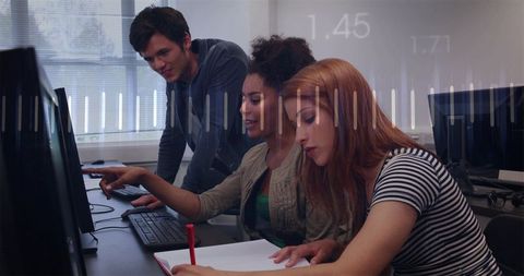 Students collaborating at computer workstations with peer mentoring and digital learning focus