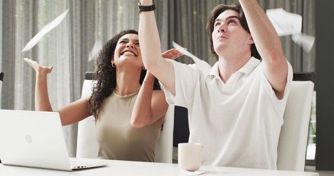 Excited Couple Celebrating Success At Home Office