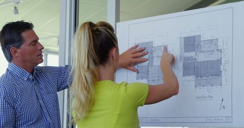 Architectural team analyzing blueprint for project development