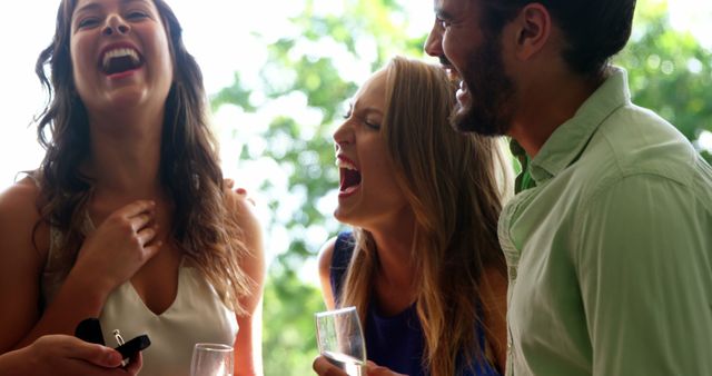 Friends Laughing and Enjoying Drinks at Outdoor Party - Download Free Stock Images Pikwizard.com