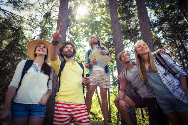 Group of friends enjoying an outdoor adventure in a forest, using a map to navigate. Ideal for themes related to travel, teamwork, nature exploration, and summer vacations. Perfect for promoting outdoor activities, hiking gear, travel destinations, and adventure tourism.