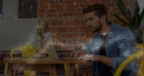 Young man working on laptop in modern rustic cafe
