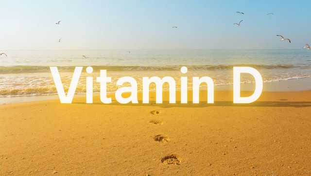 Sunlit beach showing Vitamin D text, footprints leading to shoreline with seagulls and waves
