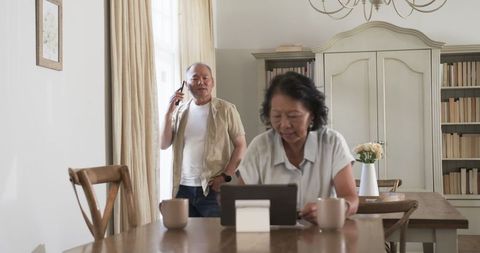 Senior Couple Engaged in Technology and Conversation at Home