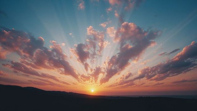 Vibrant sunrise with radiating sunrays and silhouetted hills