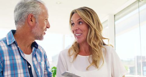 Smiling Mature Couple Holding Smartphone in Modern Home - Download Free Stock Images Pikwizard.com