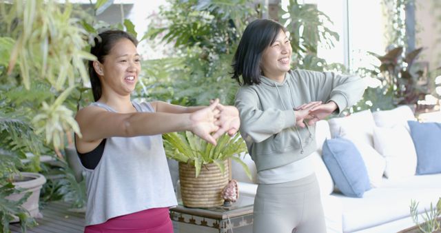 Two Women Stretching During Home Workout Session in Bright Living Room - Download Free Stock Images Pikwizard.com