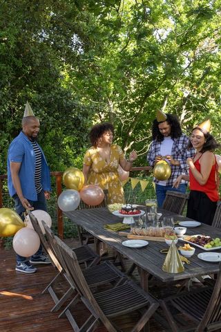 Diverse Friends Celebrating Outdoors with Balloons and Party Hats