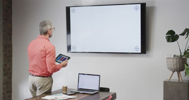 Businessman Setting Up Presentation With Tablet and Laptop - Download Free Stock Images Pikwizard.com