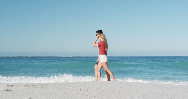 Couple Walking on Sandy Beach Against Ocean Waves on Sunny Day - Download Free Stock Images Pikwizard.com