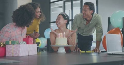 Office Birthday Celebration Showing Woman Wearing Tiara Surrounded by Laughing Coworkers