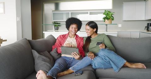 Diverse Friends Online Shopping with Tablet and Credit Card on Sofa