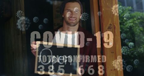 Entrepreneur holding open sign during pandemic, showing resilience