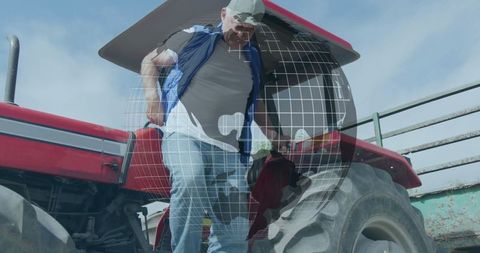 Senior farmer operating red tractor on sunny farming day