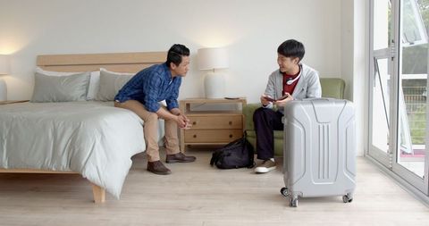 Two Men in Hotel Room Shaking Hands and Smiling
