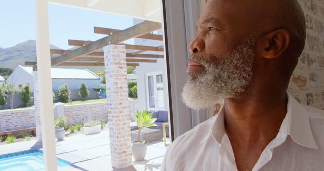 Elderly Man with Grey Beard Looking Out Window with Backyard View - Download Free Stock Images Pikwizard.com