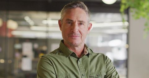 Confident Mature Executive in Modern Office with Green Shirt