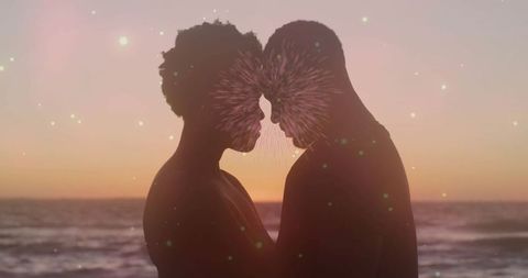 Silhouetted couple in romantic embrace at sunset beach