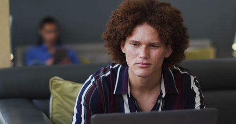 Focused Man Working at Home on Laptop with Blurred Background