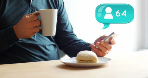 Man enjoying coffee and texting with follower notification