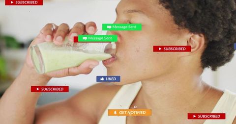 Drinking green smoothie while receiving social media notifications and subscription alerts
