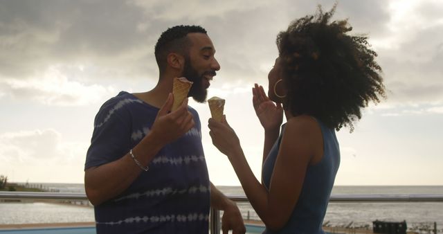 Romantic diverse couple talking and eating ice creams, copy space. Summer, vacation, romance, love, relationship, free time and lifestyle, unaltered.