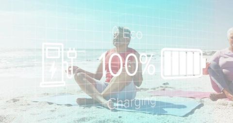 Senior couple meditating on beach with 100% battery eco charging overlay