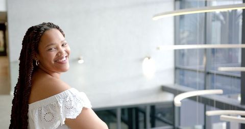 Confident Woman with Braided Hair in Modern Architectural Space