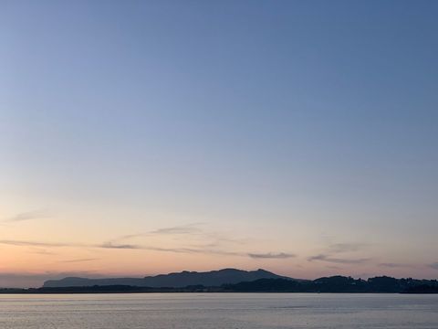Tranquil beach sunset over distant mountains