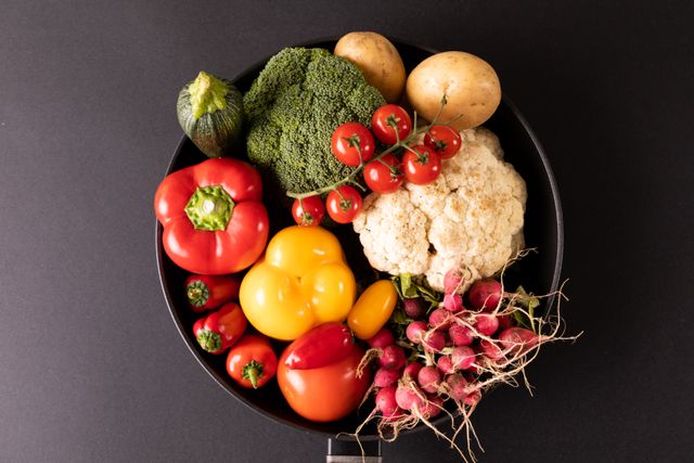 Directly above view of various fresh vegetables in bowl over gray background. unaltered, organic food and healthy eating concept.