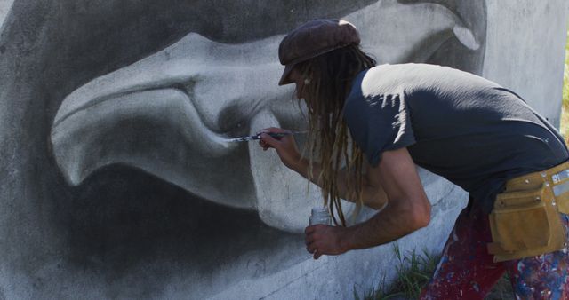 Image of caucasian male artist with dreadlocks painting whale mural on wall - Download Free Stock Photos Pikwizard.com