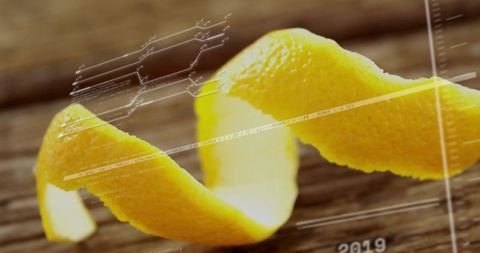 Twisted lemon peel spiral on rustic wooden tabletop with digital hud overlay macro closeup