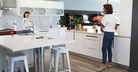 Mature Women Cleaning After Party in Modern Kitchen