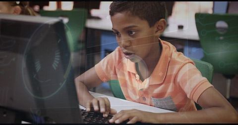 Young student concentrating on coding in classroom computer lab with futuristic hud overlay