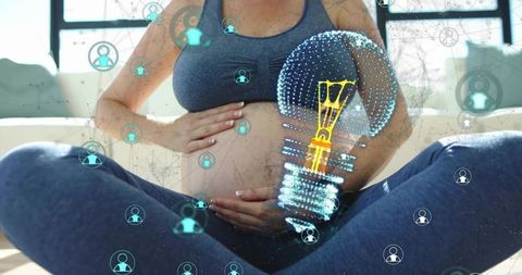 Pregnant woman cradling belly in athleisure with holographic lightbulb network overlay