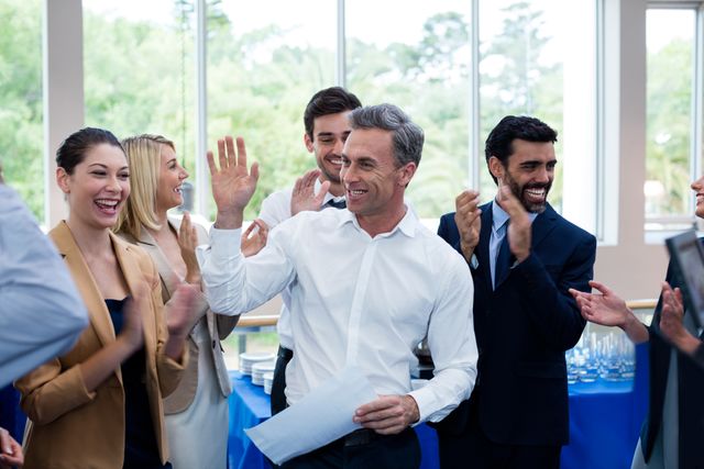 Happy business executives giving high five in conference center