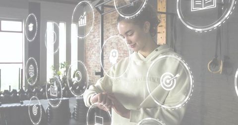 Young woman checking smartwatch in industrial gym with digital fitness ui overlays, brick studio