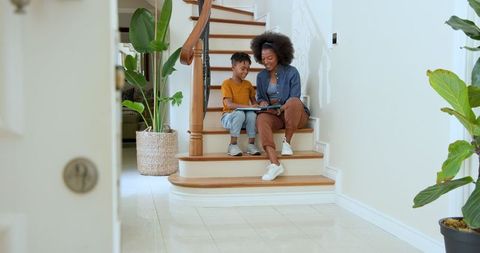 Mother and Son Reading on Staircase at Home