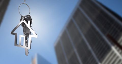 House Key Dangling Against City Skyscrapers Backdrop