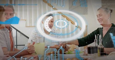 Mature adults sharing meal while using augmented reality interface overlay at home