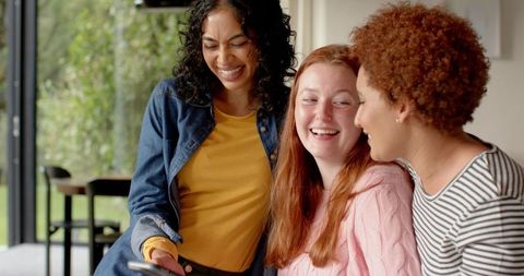 Diverse Female Friends Sharing Joyful Moment with Smartphone